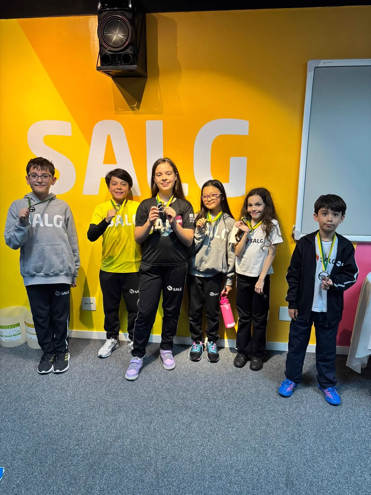 Grupo de alunos dos anos iniciais com suas medalhas da Olimpíada Canguru
